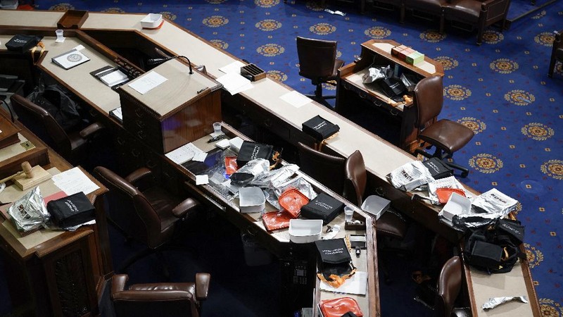 People shelter in the House gallery as protesters try to break into the House Chamber at the U.S. Capitol on Wednesday, Jan. 6, 2021, in Washington. (AP Photo/Andrew Harnik)