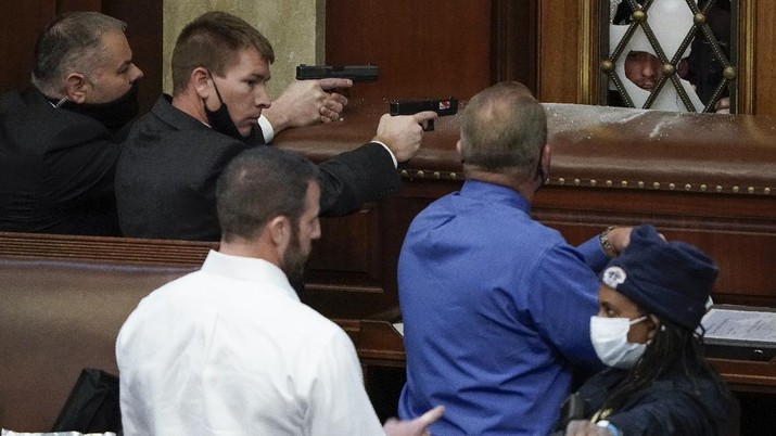 Congress Electoral College U.S. Capitol Police with guns drawn watch as protesters try to break into the House Chamber at the U.S. Capitol on Wednesday, Jan. 6, 2021, in Washington. (AP Photo/J. Scott Applewhite)
