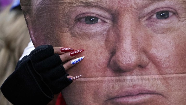 Electoral College Protests A woman holds a cut out of President Donald Trump's face Wednesday, Jan. 6, 2021, in Washington, at a rally in support of President Donald Trump called the