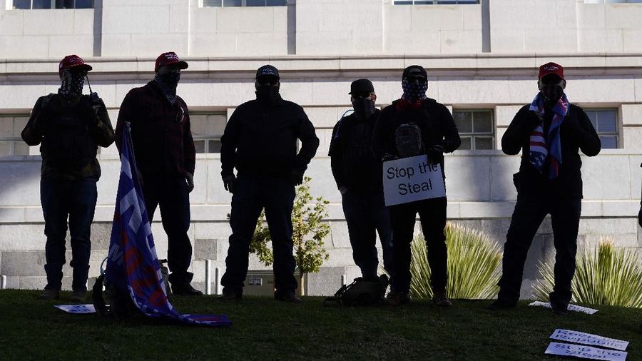 A Trump supporter is detained by LAPD officers after a brawl with counter protesters  in Los Angeles on Wednesday, Jan. 6, 2021. (Sarah Reingewirtz/The Orange County Register via AP)