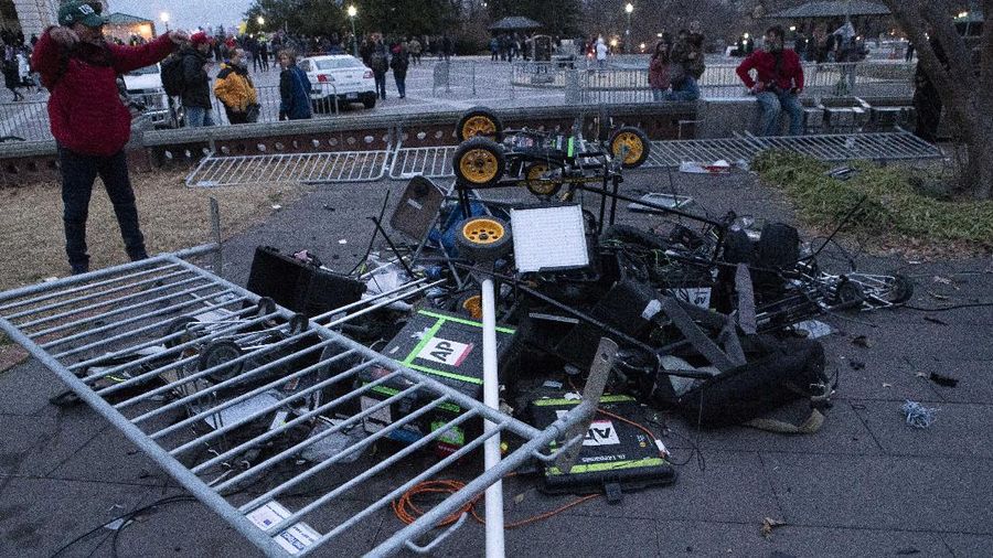 Demonstrators break TV equipment outside the the U.S. Capitol on Wednesday, Jan. 6, 2021, in Washington.  (AP Photo/Jose Luis Magana)