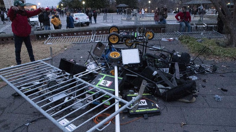 Demonstrators break TV equipment outside the the U.S. Capitol on Wednesday, Jan. 6, 2021, in Washington.  (AP Photo/Jose Luis Magana)