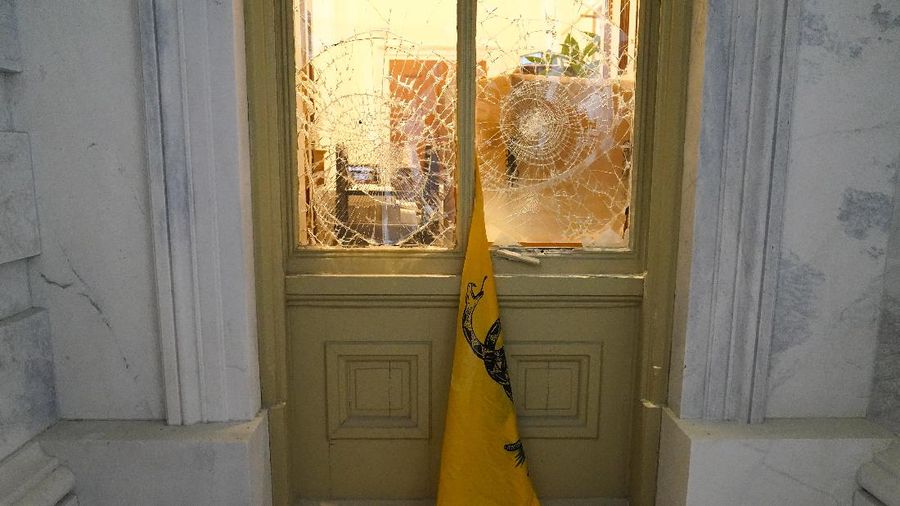 People shelter in the House gallery as protesters try to break into the House Chamber at the U.S. Capitol on Wednesday, Jan. 6, 2021, in Washington. (AP Photo/Andrew Harnik)