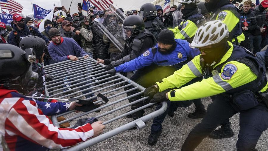 Trump supporters try to break through a police barrier, Wednesday, Jan. 6, 2021, at the Capitol in Washington. As Congress prepares to affirm President-elect Joe Biden's victory, thousands of people have gathered to show their support for President Donald Trump and his claims of election fraud.(AP Photo/John Minchillo)