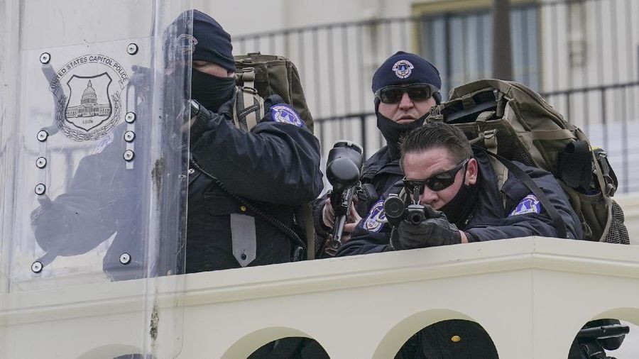 Police keep a watch on demonstrators who tried to break through a police barrier, Wednesday, Jan. 6, 2021, at the Capitol in Washington. As Congress prepares to affirm President-elect Joe Biden's victory, thousands of people have gathered to show their support for President Donald Trump and his claims of election fraud.(AP Photo/John Minchillo)