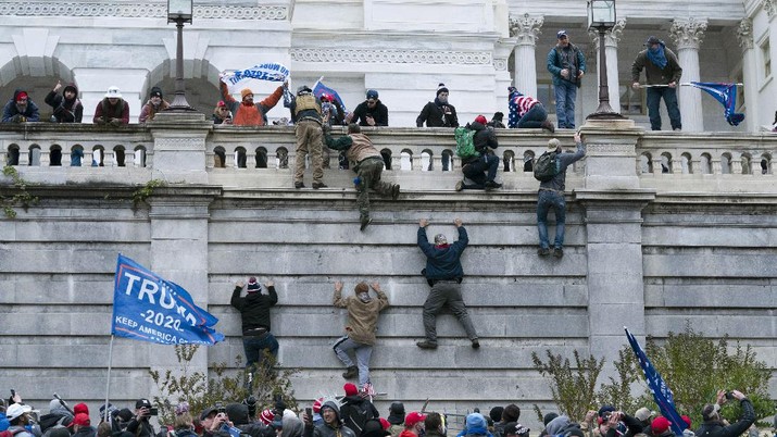 Pendukung Trump Serang Gedung Capitol Supporters of President Donald Trump climb the west wall of the the U.S. Capitol on Wednesday, Jan. 6, 2021, in Washington. (AP Photo/Jose Luis Magana)