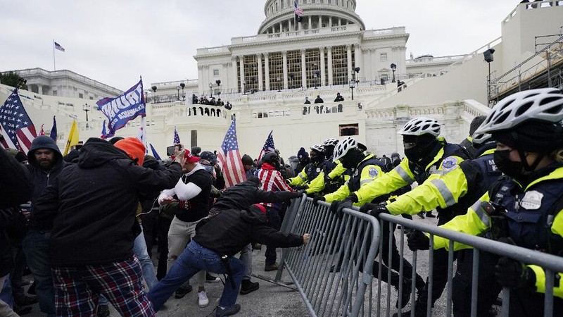 Trump supporters try to break through a police barrier, Wednesday, Jan. 6, 2021, at the Capitol in Washington. As Congress prepares to affirm President-elect Joe Biden's victory, thousands of people have gathered to show their support for President Donald Trump and his claims of election fraud. (AP Photo/Julio Cortez)