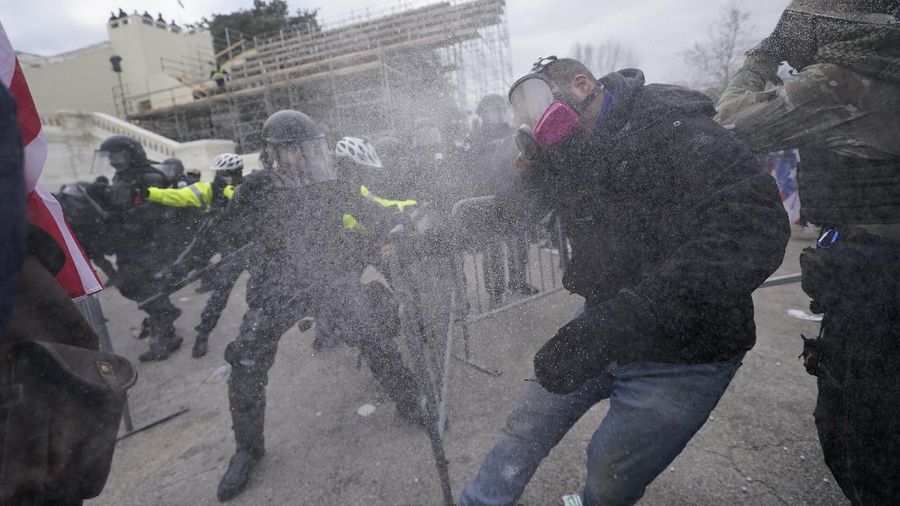 Trump supporters try to break through a police barrier, Wednesday, Jan. 6, 2021, at the Capitol in Washington. As Congress prepares to affirm President-elect Joe Biden's victory, thousands of people have gathered to show their support for President Donald Trump and his claims of election fraud. (AP Photo/Julio Cortez)
