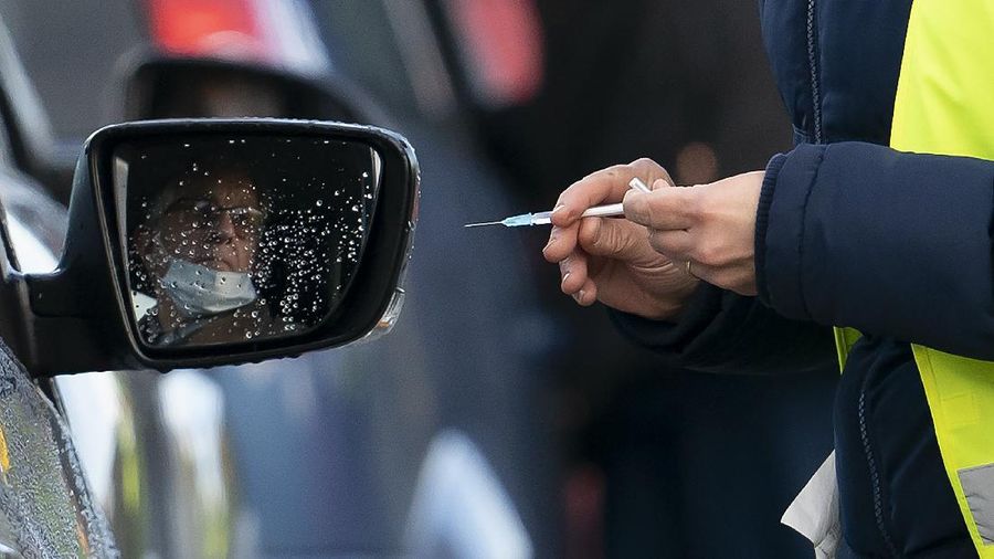 A member of staff administers the Pfizer-BioNtech COVID-19 vaccine to a member of the public at Hyde Leisure Centre near, England, Friday Jan. 8, 2021. Mass vaccination hubs in London, Newcastle, Manchester, Birmingham, Bristol, Surrey and Stevenage are due to begin operations next week. ( AP Photo/Jon Super)