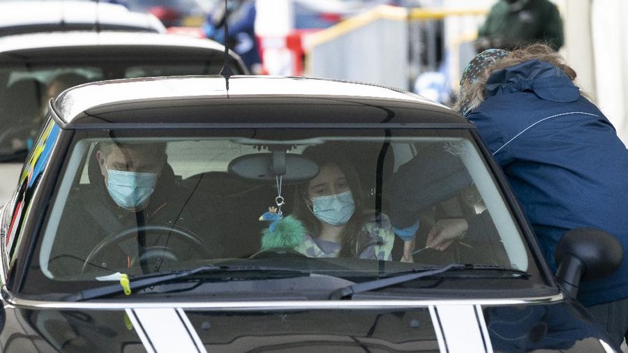 A member of staff administers the Pfizer-BioNtech COVID-19 vaccine to a member of the public at Hyde Leisure Centre near, England, Friday Jan. 8, 2021. Mass vaccination hubs in London, Newcastle, Manchester, Birmingham, Bristol, Surrey and Stevenage are due to begin operations next week. ( AP Photo/Jon Super)