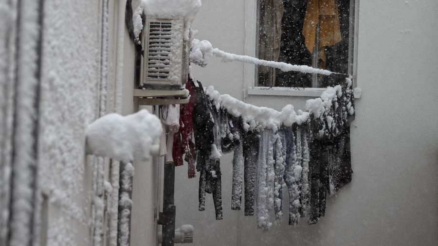 Two men walk slowly in the middle of a street after a heavy snowfall in Madrid, Spain, Saturday, Jan. 9, 2021. Spain is on high alert as a cold snap is covering much of the country with snow disrupting road, sea, rail and air traffic with the capital, Madrid enduring what the city's mayor described as 