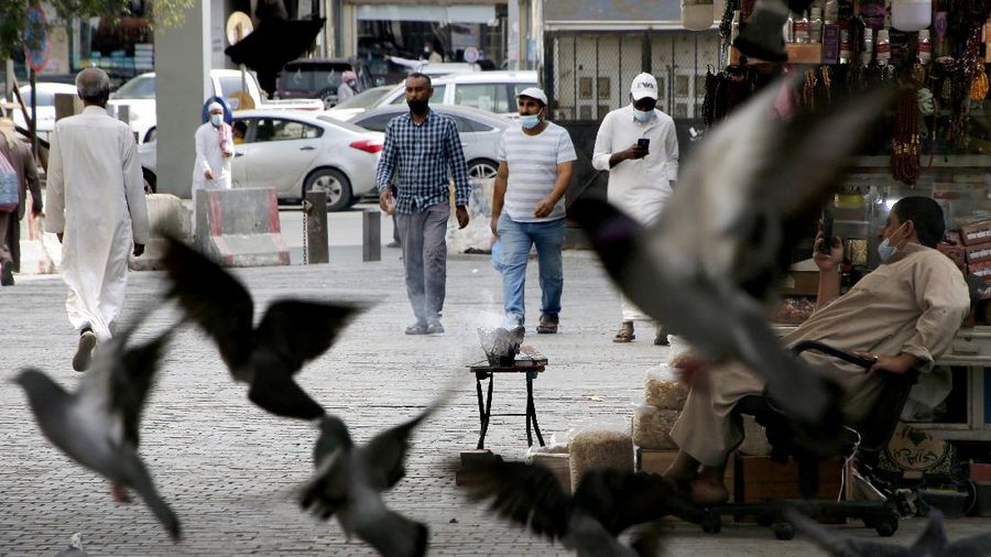 People wearing face masks to help curb the spread of the coronavirus, as they walk at Jiddah old city, Saudi Arabia, Thursday, Dec. 17, 2020. (AP Photo/Amr Nabil)