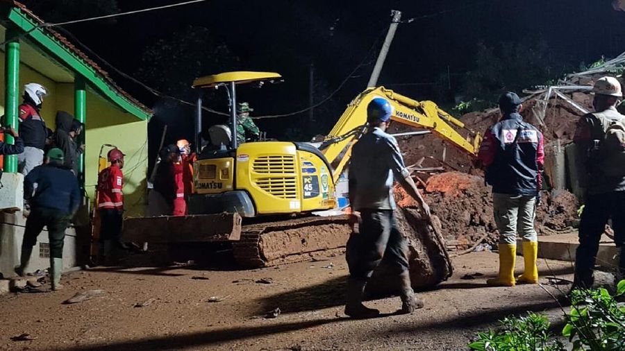 In this photo provided by the Indonesian National Disaster Mitigation Agency, rescuers work the scene of a landslide in Cihanjuang village, Indonesia, early Sunday, Jan. 10, 2021. Two landslides in the Sumedang district of West Java province triggered by heavy rain in Indonesia left multiple people dead and injured, officials said Sunday.  (Indonesian National Disaster Mitigation Agency via AP)