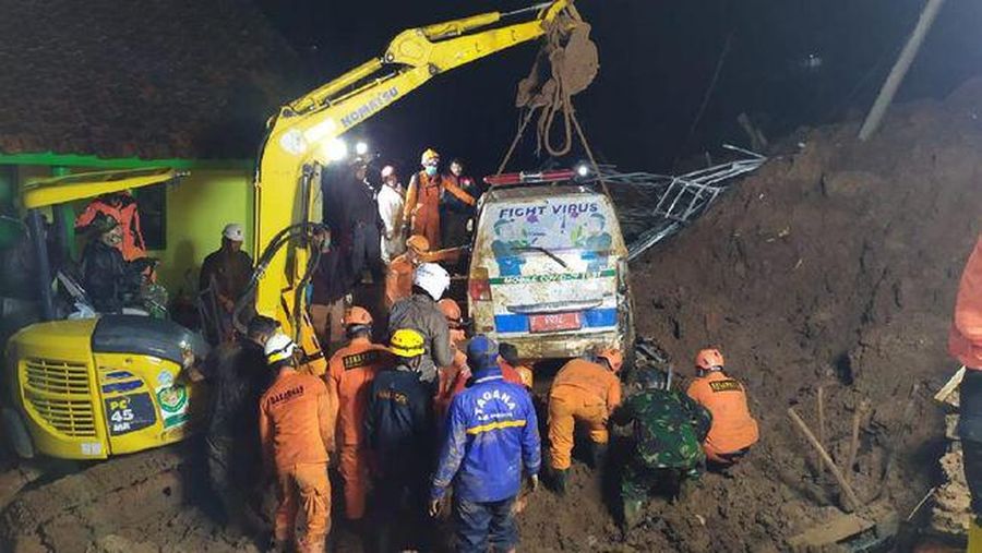 In this photo provided by the Indonesian National Disaster Mitigation Agency, rescuers work the scene of a landslide in Cihanjuang village, Indonesia, early Sunday, Jan. 10, 2021. Two landslides in the Sumedang district of West Java province triggered by heavy rain in Indonesia left multiple people dead and injured, officials said Sunday.  (Indonesian National Disaster Mitigation Agency via AP)