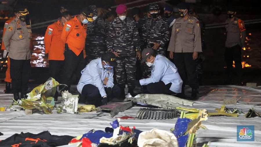 Tim Sar membawa temuan sebagian pesawat dari air selama operasi pencarian jet penumpang Sriwijaya Air yang jatuh ke laut dekat Jakarta, Indonesia, Minggu, 10 Januari 2021.
