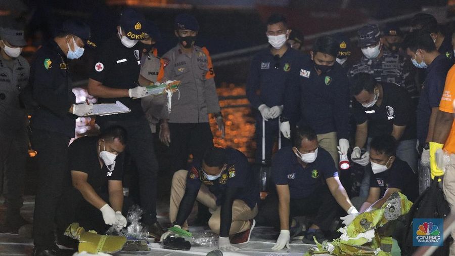 Tim Sar membawa temuan sebagian pesawat dari air selama operasi pencarian jet penumpang Sriwijaya Air yang jatuh ke laut dekat Jakarta, Indonesia, Minggu, 10 Januari 2021.