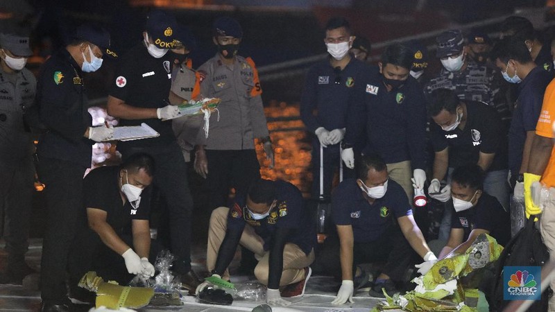 Tim Sar membawa temuan sebagian pesawat dari air selama operasi pencarian jet penumpang Sriwijaya Air yang jatuh ke laut dekat Jakarta, Indonesia, Minggu, 10 Januari 2021.