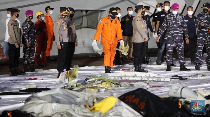 Tim Sar membawa temuan sebagian pesawat dari air selama operasi pencarian jet penumpang Sriwijaya Air yang jatuh ke laut dekat Jakarta, Indonesia, Minggu, 10 Januari 2021.