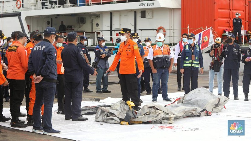 Petugas SAR memeriksa temuan tangga darurat dari kecelakaan pesawat Sriwijaya pesawat Sriwijaya Air SJ-182 di wilayah Kepulauan Seribu, Jakarta, Minggu (10/1/2021).  (CNBC Indonesia/Andrean Kristianto)