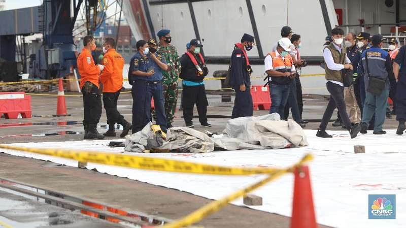 Petugas SAR memeriksa temuan tangga darurat dari kecelakaan pesawat Sriwijaya pesawat Sriwijaya Air SJ-182 di wilayah Kepulauan Seribu, Jakarta, Minggu (10/1/2021).  (CNBC Indonesia/Andrean Kristianto)