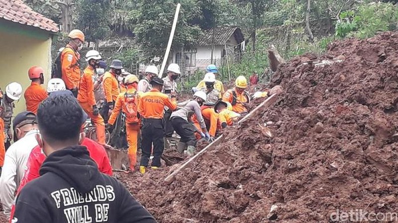 In this photo provided by the Indonesian National Disaster Mitigation Agency, rescuers work the scene of a landslide in Cihanjuang village, Indonesia, early Sunday, Jan. 10, 2021. Two landslides in the Sumedang district of West Java province triggered by heavy rain in Indonesia left multiple people dead and injured, officials said Sunday.  (Indonesian National Disaster Mitigation Agency via AP)