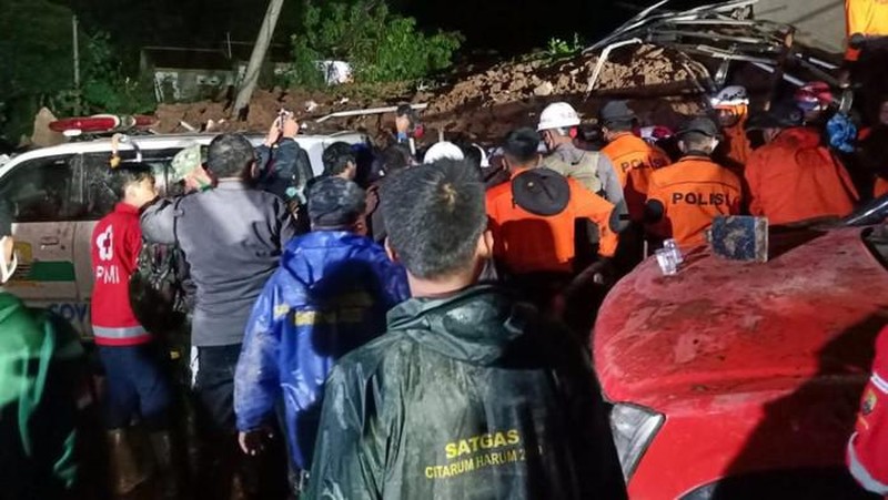 In this photo provided by the Indonesian National Disaster Mitigation Agency, rescuers work the scene of a landslide in Cihanjuang village, Indonesia, early Sunday, Jan. 10, 2021. Two landslides in the Sumedang district of West Java province triggered by heavy rain in Indonesia left multiple people dead and injured, officials said Sunday.  (Indonesian National Disaster Mitigation Agency via AP)