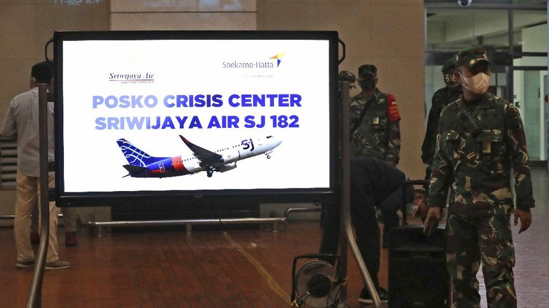 Kerabat penumpang menunggu laporan informasi keterangan Pesawat Sriwajaya Air di posko krisis Sriwijaya Air di Bandara Internasional Soekarno-Hatta di Tangerang, Indonesia, Sabtu, 9 Januari. , 2021.(AP Photo/Tatan Syuflana)