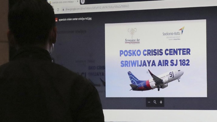 Kerabat penumpang menunggu laporan informasi keterangan Pesawat Sriwajaya Air di posko krisis Sriwijaya Air di Bandara Internasional Soekarno-Hatta di Tangerang, Indonesia, Sabtu, 9 Januari. , 2021.(AP Photo/Tatan Syuflana)