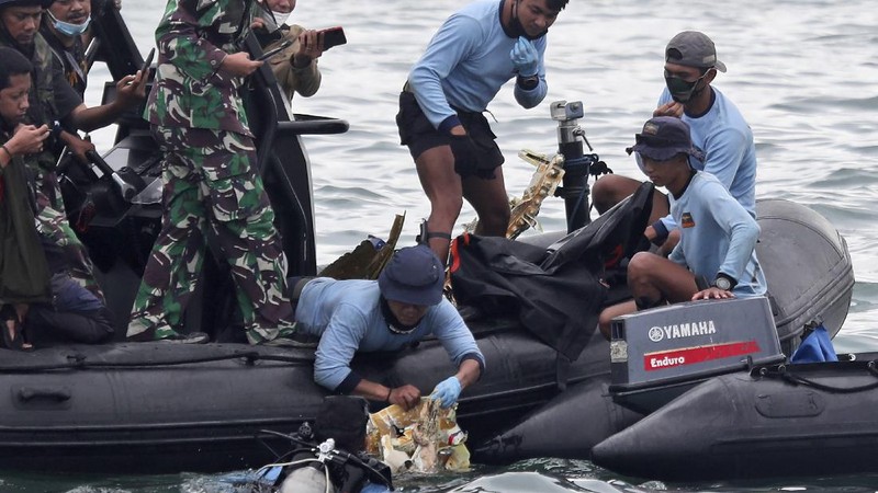 Penyelam Angkatan Laut Indonesia menemukan sebagian pesawat dari air selama operasi pencarian jet penumpang Sriwijaya Air yang jatuh ke laut dekat Jakarta, Indonesia, Minggu, 10 Januari 2021. (AP Photo/Achmad Ibrahim)