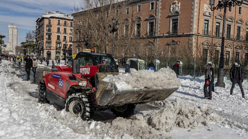 A man snowboards at the Gran Via avenue in downtown Madrid, Spain, Sunday, Jan. 10, 2021. A large part of central Spain including the capital of Madrid are slowly clearing snow after the country's worst snowstorm in recent memory. (AP Photo/Manu Fernandez)
