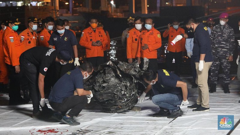 Prajurit TNI AL menurunkan bagian mesin turbin pesawat Sriwijaya Air SJ182 rute Jakarta-Pontianak dari KRI Cucut (886) di Dermaga JICT, Tanjung Priok, Jakarta, Minggu (10/1/2021). (CNBC Indonesia/ Andrean Kristianto)
