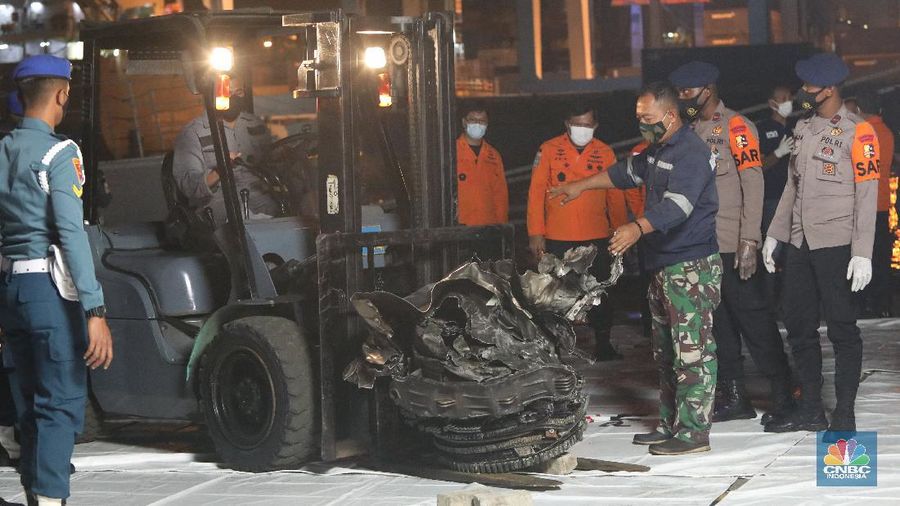 Prajurit TNI AL menurunkan bagian mesin turbin pesawat Sriwijaya Air SJ182 rute Jakarta-Pontianak dari KRI Cucut (886) di Dermaga JICT, Tanjung Priok, Jakarta, Minggu (10/1/2021). (CNBC Indonesia/ Andrean Kristianto)
