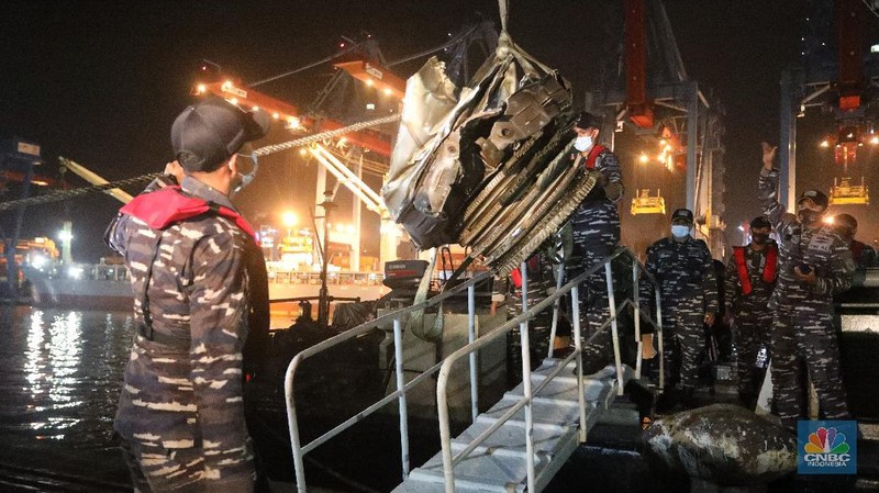 Prajurit TNI AL menurunkan bagian mesin turbin pesawat Sriwijaya Air SJ182 rute Jakarta-Pontianak dari KRI Cucut (886) di Dermaga JICT, Tanjung Priok, Jakarta, Minggu (10/1/2021). (CNBC Indonesia/ Andrean Kristianto)