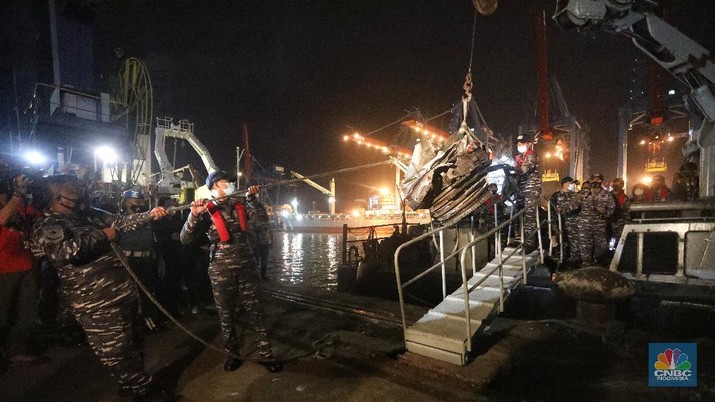 Prajurit TNI AL menurunkan bagian mesin turbin pesawat Sriwijaya Air SJ182 rute Jakarta-Pontianak dari KRI Cucut (886) di Dermaga JICT, Tanjung Priok, Jakarta, Minggu (10/1/2021). (CNBC Indonesia/ Andrean Kristianto)