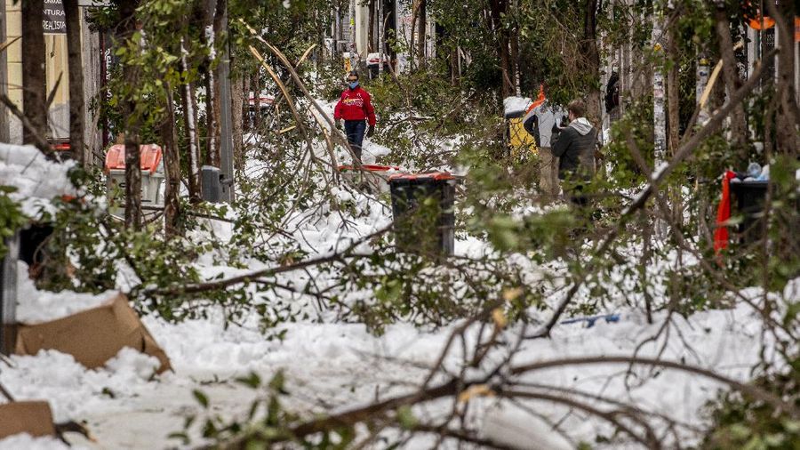 A man snowboards at the Gran Via avenue in downtown Madrid, Spain, Sunday, Jan. 10, 2021. A large part of central Spain including the capital of Madrid are slowly clearing snow after the country's worst snowstorm in recent memory. (AP Photo/Manu Fernandez)