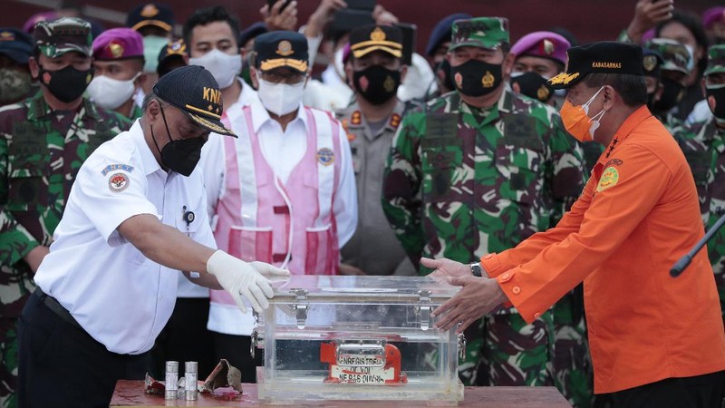 Members of the National Transportation Safety Committee carry a box containing the flight data recorder of Sriwijaya Air flight SJ-182 retrieved from the Java Sea where the passenger jet crashed at the Tanjung Priok Port, Tuesday, Jan. 12, 2021. Indonesian navy divers searching the ocean floor on Tuesday recovered the flight data recorder from a Sriwijaya Air jet that crashed into the Java Sea with 62 people on board, Monday, Jan. 11, 2021. (AP Photo/Dita Alangkara)