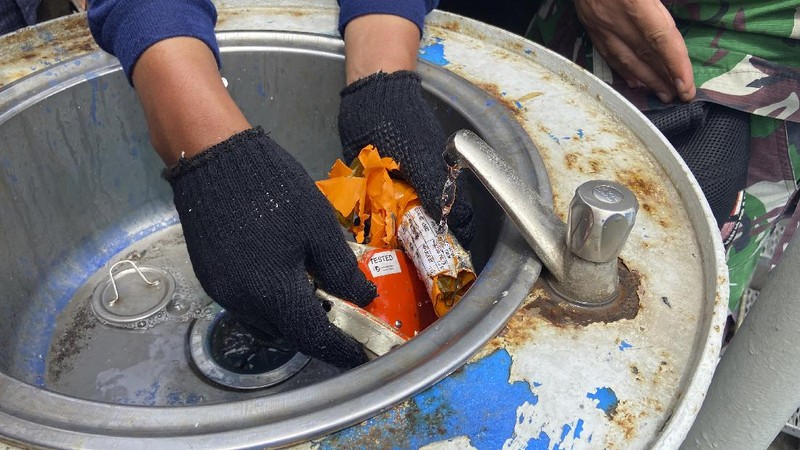 Members of the National Transportation Safety Committee carry a box containing the flight data recorder of Sriwijaya Air flight SJ-182 retrieved from the Java Sea where the passenger jet crashed at the Tanjung Priok Port, Tuesday, Jan. 12, 2021. Indonesian navy divers searching the ocean floor on Tuesday recovered the flight data recorder from a Sriwijaya Air jet that crashed into the Java Sea with 62 people on board, Monday, Jan. 11, 2021. (AP Photo/Dita Alangkara)