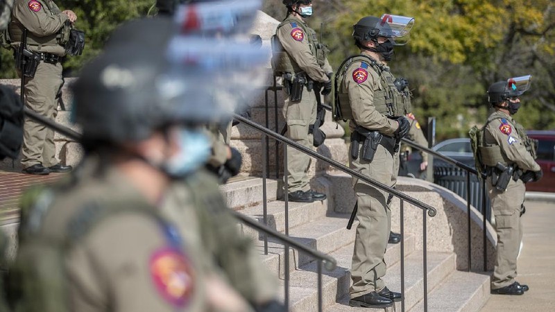 DPS state troopers and the National Guard protect the Capitol on the first day of the 87th Legislature, Tuesday Jan. 12, 2021 in Austin, Texas. More than 100 Texas troopers, including dozens wearing tactical vests and carrying riot gear, stood on guard outside the state Capitol on Tuesday as lawmakers returned to work amid FBI warnings of armed protests at statehouses across the country. (Ricardo B. Brazziell/Austin American-Statesman via AP)
