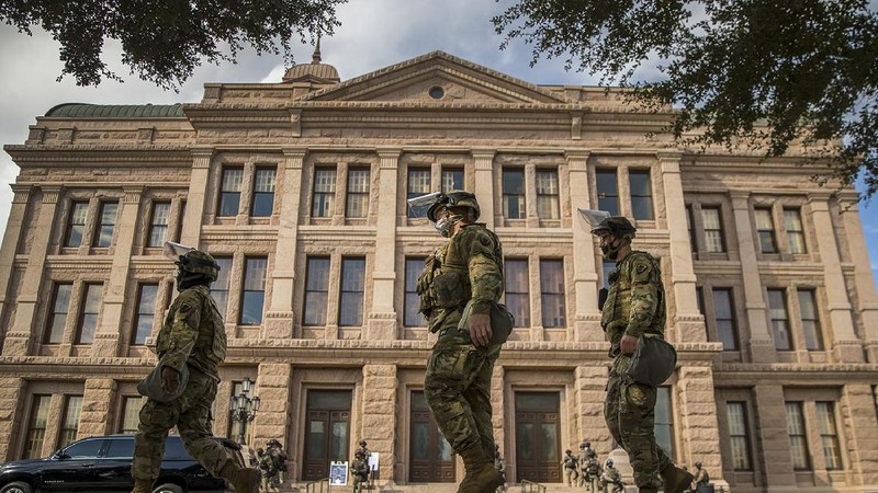 DPS state troopers and the National Guard protect the Capitol on the first day of the 87th Legislature, Tuesday Jan. 12, 2021 in Austin, Texas. More than 100 Texas troopers, including dozens wearing tactical vests and carrying riot gear, stood on guard outside the state Capitol on Tuesday as lawmakers returned to work amid FBI warnings of armed protests at statehouses across the country. (Ricardo B. Brazziell/Austin American-Statesman via AP)
