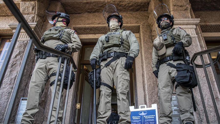 DPS state troopers and the National Guard protect the Capitol on the first day of the 87th Legislature, Tuesday Jan. 12, 2021 in Austin, Texas. More than 100 Texas troopers, including dozens wearing tactical vests and carrying riot gear, stood on guard outside the state Capitol on Tuesday as lawmakers returned to work amid FBI warnings of armed protests at statehouses across the country. (Ricardo B. Brazziell/Austin American-Statesman via AP)