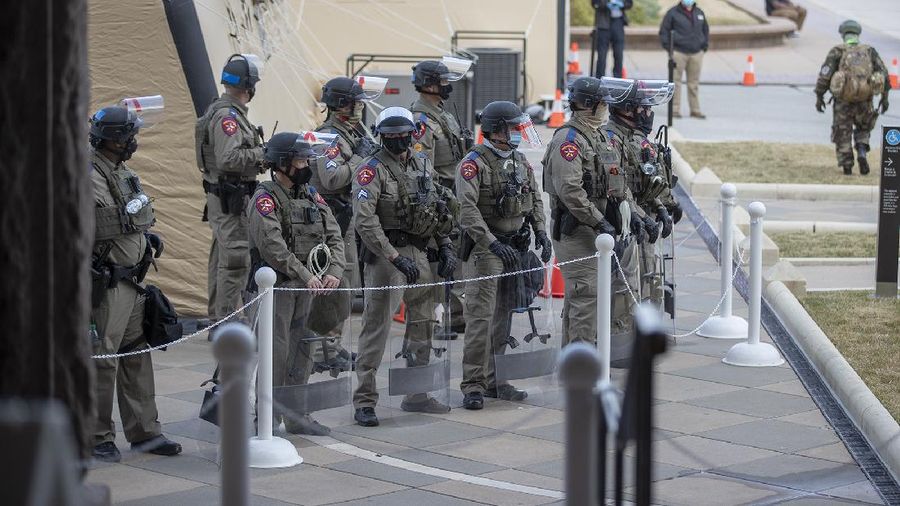 DPS state troopers and the National Guard protect the Capitol on the first day of the 87th Legislature, Tuesday Jan. 12, 2021 in Austin, Texas. More than 100 Texas troopers, including dozens wearing tactical vests and carrying riot gear, stood on guard outside the state Capitol on Tuesday as lawmakers returned to work amid FBI warnings of armed protests at statehouses across the country. (Ricardo B. Brazziell/Austin American-Statesman via AP)