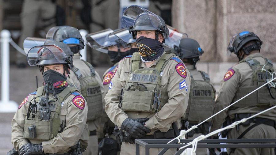 DPS state troopers and the National Guard protect the Capitol on the first day of the 87th Legislature, Tuesday Jan. 12, 2021 in Austin, Texas. More than 100 Texas troopers, including dozens wearing tactical vests and carrying riot gear, stood on guard outside the state Capitol on Tuesday as lawmakers returned to work amid FBI warnings of armed protests at statehouses across the country. (Ricardo B. Brazziell/Austin American-Statesman via AP)