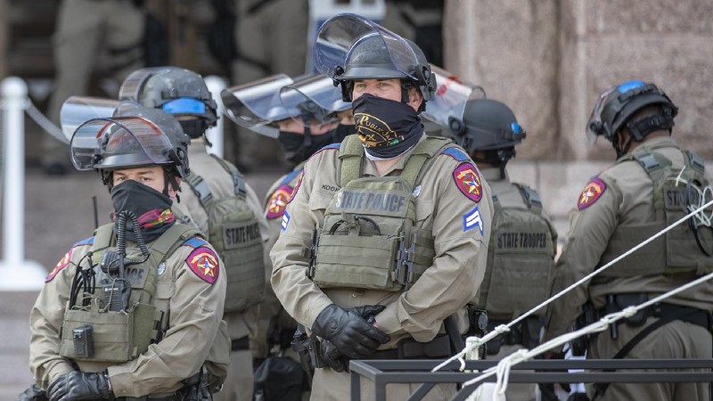 DPS state troopers and the National Guard protect the Capitol on the first day of the 87th Legislature, Tuesday Jan. 12, 2021 in Austin, Texas. More than 100 Texas troopers, including dozens wearing tactical vests and carrying riot gear, stood on guard outside the state Capitol on Tuesday as lawmakers returned to work amid FBI warnings of armed protests at statehouses across the country. (Ricardo B. Brazziell/Austin American-Statesman via AP)