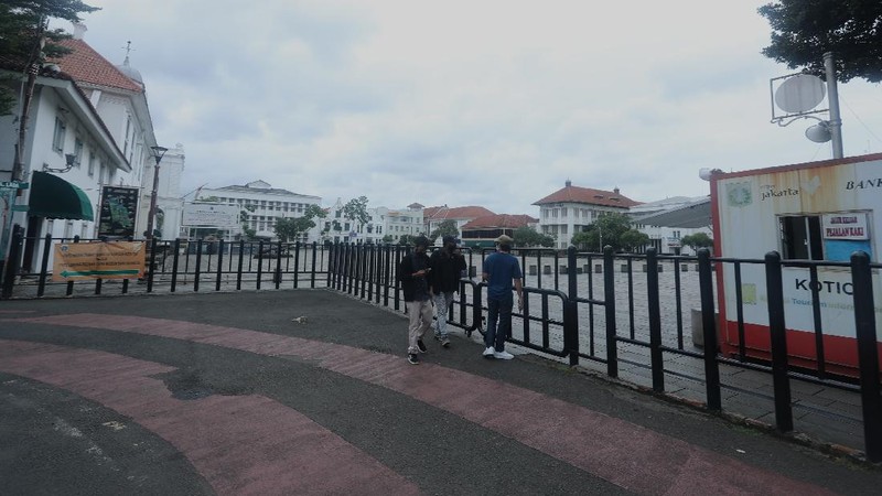 Sejumlah warga melewati Jalan Pintu Besar Utara yabg ditutup di kawasan Kota Tua, Jakarta, Rabu (13/1/2021). Pemerintah Kota Administrasi Jakarta Barat menutup sejumlah ruas jalan menuju kawasan wisata Kota Tua selama Pemberlakuan Pembatasan Kegiatan Masyarakat (PPKM) di DKI Jakarta pada 11 Januari hingga 25 Januari 2021 untuk mencegah kerumunan. (CNBC Indonesia/Tri Susilo)
Pantauan CNBC Indonesia kemacetan tidak terhindarkan kendaraan dari arah Harmoni menuju Jalan Pintu Besar Utara karena banyak pengguna jalan yang belum mengetahui penutupan jalur. 
Salah satu satgas Kota Tua yang tidak ingin disebutkan namanya mengatakan 