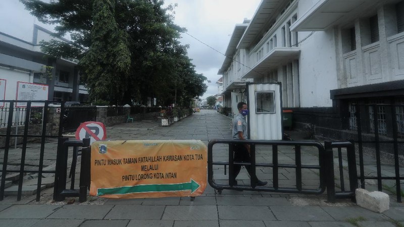 Sejumlah warga melewati Jalan Pintu Besar Utara yabg ditutup di kawasan Kota Tua, Jakarta, Rabu (13/1/2021). Pemerintah Kota Administrasi Jakarta Barat menutup sejumlah ruas jalan menuju kawasan wisata Kota Tua selama Pemberlakuan Pembatasan Kegiatan Masyarakat (PPKM) di DKI Jakarta pada 11 Januari hingga 25 Januari 2021 untuk mencegah kerumunan. (CNBC Indonesia/Tri Susilo)
Pantauan CNBC Indonesia kemacetan tidak terhindarkan kendaraan dari arah Harmoni menuju Jalan Pintu Besar Utara karena banyak pengguna jalan yang belum mengetahui penutupan jalur. 
Salah satu satgas Kota Tua yang tidak ingin disebutkan namanya mengatakan 