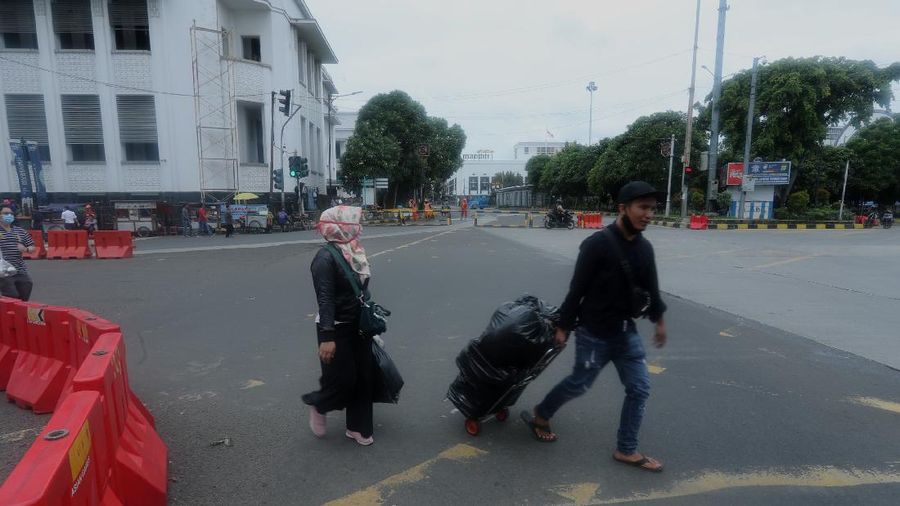 Sejumlah warga melewati Jalan Pintu Besar Utara yabg ditutup di kawasan Kota Tua, Jakarta, Rabu (13/1/2021). Pemerintah Kota Administrasi Jakarta Barat menutup sejumlah ruas jalan menuju kawasan wisata Kota Tua selama Pemberlakuan Pembatasan Kegiatan Masyarakat (PPKM) di DKI Jakarta pada 11 Januari hingga 25 Januari 2021 untuk mencegah kerumunan. (CNBC Indonesia/Tri Susilo)
Pantauan CNBC Indonesia kemacetan tidak terhindarkan kendaraan dari arah Harmoni menuju Jalan Pintu Besar Utara karena banyak pengguna jalan yang belum mengetahui penutupan jalur. 
Salah satu satgas Kota Tua yang tidak ingin disebutkan namanya mengatakan 