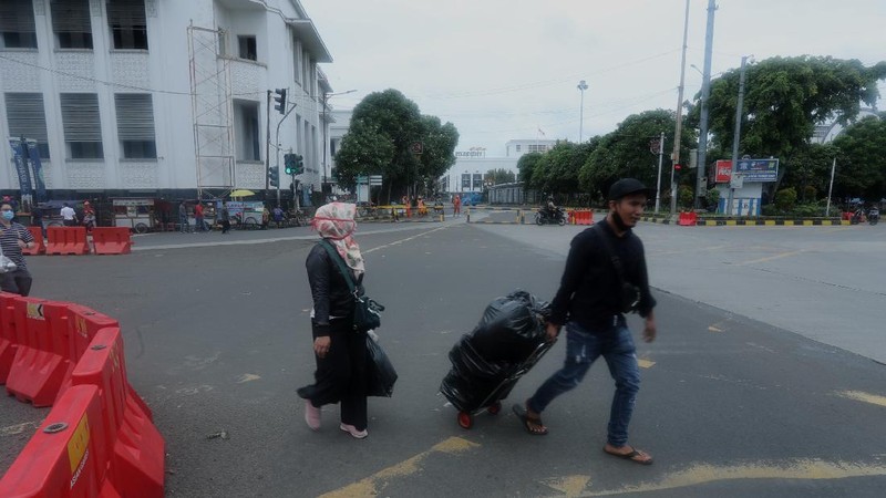 Sejumlah warga melewati Jalan Pintu Besar Utara yabg ditutup di kawasan Kota Tua, Jakarta, Rabu (13/1/2021). Pemerintah Kota Administrasi Jakarta Barat menutup sejumlah ruas jalan menuju kawasan wisata Kota Tua selama Pemberlakuan Pembatasan Kegiatan Masyarakat (PPKM) di DKI Jakarta pada 11 Januari hingga 25 Januari 2021 untuk mencegah kerumunan. (CNBC Indonesia/Tri Susilo)
Pantauan CNBC Indonesia kemacetan tidak terhindarkan kendaraan dari arah Harmoni menuju Jalan Pintu Besar Utara karena banyak pengguna jalan yang belum mengetahui penutupan jalur. 
Salah satu satgas Kota Tua yang tidak ingin disebutkan namanya mengatakan 