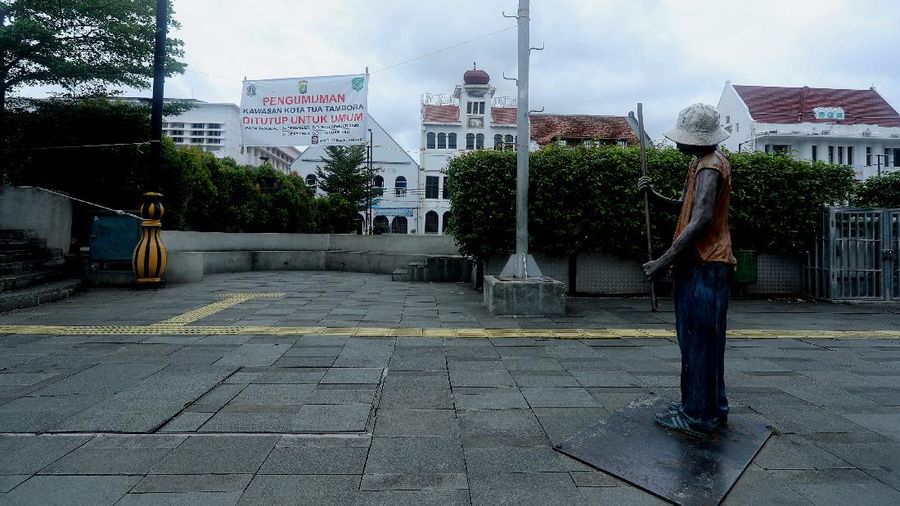 Sejumlah warga melewati Jalan Pintu Besar Utara yabg ditutup di kawasan Kota Tua, Jakarta, Rabu (13/1/2021). Pemerintah Kota Administrasi Jakarta Barat menutup sejumlah ruas jalan menuju kawasan wisata Kota Tua selama Pemberlakuan Pembatasan Kegiatan Masyarakat (PPKM) di DKI Jakarta pada 11 Januari hingga 25 Januari 2021 untuk mencegah kerumunan. (CNBC Indonesia/Tri Susilo)
Pantauan CNBC Indonesia kemacetan tidak terhindarkan kendaraan dari arah Harmoni menuju Jalan Pintu Besar Utara karena banyak pengguna jalan yang belum mengetahui penutupan jalur. 
Salah satu satgas Kota Tua yang tidak ingin disebutkan namanya mengatakan 