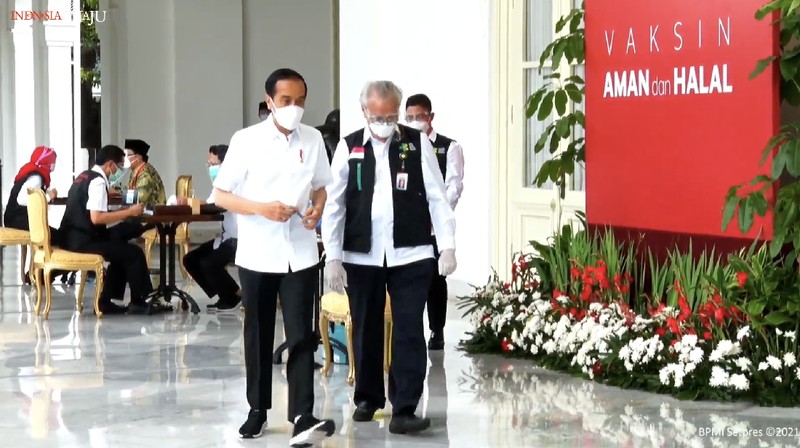 In this photo released by the Indonesian Presidential Palace, President Joko Widodo prepares to receive a shot of COVID-19 vaccine at Merdeka Palace in Jakarta, Indonesia, Wednesday, Jan. 13, 2021. Widodo on Wednesday received the first shot of a Chinese-made COVID-19 vaccine after Indonesia approved it for emergency use and began efforts to vaccine millions of people in the world's fourth most populated country. Writings on the banner in the background read 