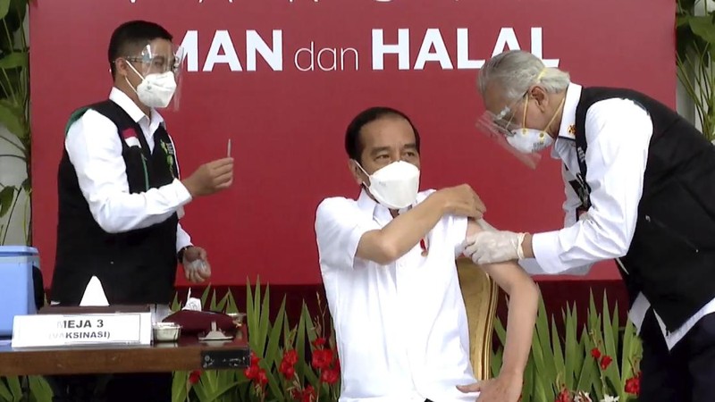 In this photo released by the Indonesian Presidential Palace, President Joko Widodo prepares to receive a shot of COVID-19 vaccine at Merdeka Palace in Jakarta, Indonesia, Wednesday, Jan. 13, 2021. Widodo on Wednesday received the first shot of a Chinese-made COVID-19 vaccine after Indonesia approved it for emergency use and began efforts to vaccine millions of people in the world's fourth most populated country. Writings on the banner in the background read 